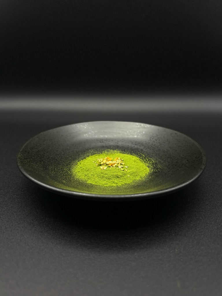 Ceremonial-grade japanese matcha powder on a black plate with gold leaf — premium matcha powder for wholesale and bulk supply